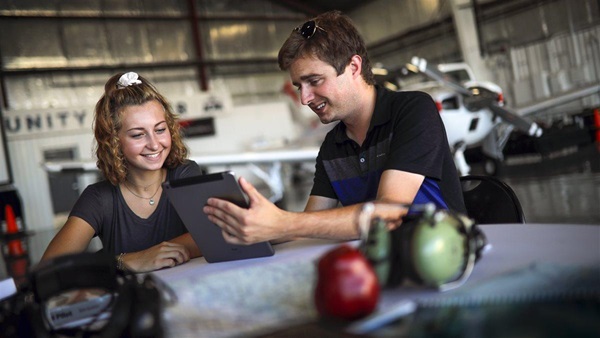 student and instructor reviewing weather or flight plan on a portable tablet